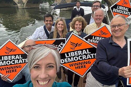 Clive Jones, Daisy Cooper and others on a boat with Lib Dem signs