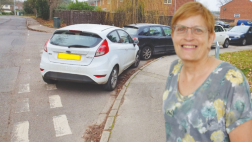 Rachelle by a corner blocked with parked cars