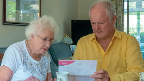 Clive and an elderly lady looking at a bill