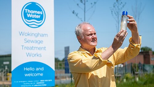 Clive looking at a sample of dirty looking water outside Thames Water