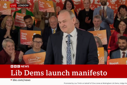Ed Davey launching manifesto on BBC with Clive in background