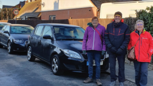 Prue, Paul and Rachelle on a street with tightly packed parked cars